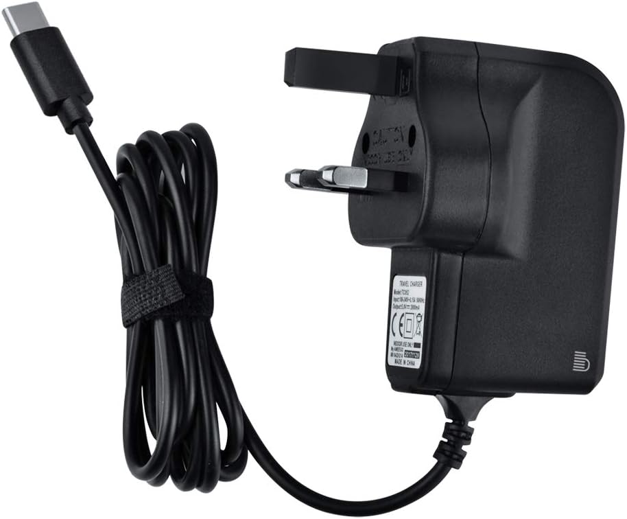 Black USB-C power adapter with a coiled cable and UK three-pin plug on a white background.